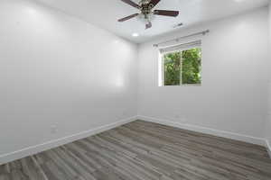 Empty room featuring wood finished floors, ceiling fan, and recessed lighting