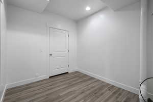 Empty room with wood finished floors and recessed lighting