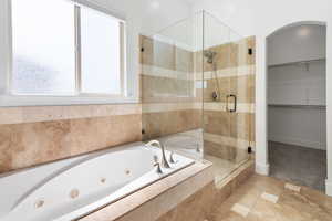 Bathroom with a stall shower, a tub with jets, and a spacious closet