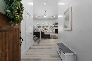 Entrance foyer featuring recessed lighting, a fireplace with raised hearth, light wood-style floors, a ceiling fan, and stairway