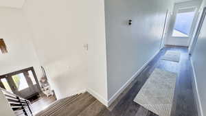 Hallway featuring dark wood-style floors and stairway