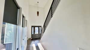 Hall featuring a high ceiling, stairs, and dark wood-type flooring