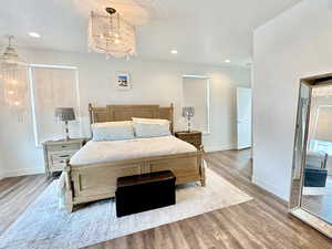 Bedroom with a chandelier, light wood-type flooring, and recessed lighting