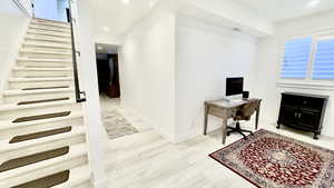 Office area with light wood-style floors and recessed lighting