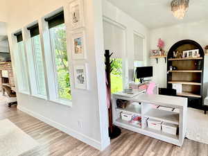 Office space featuring light wood-style floors and a chandelier