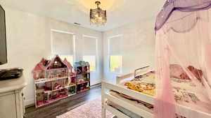 Bedroom featuring dark wood-style floors and baseboards