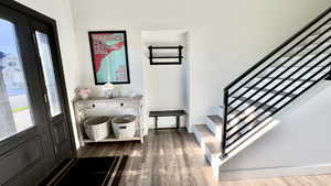 Entryway with dark wood-style floors and stairway