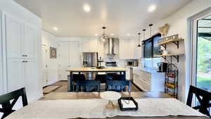 Kitchen featuring white cabinetry, hanging light fixtures, open shelves, stainless steel appliances, and recessed lighting