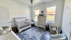 Bedroom featuring a crib and wood finished floors
