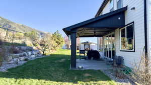 View of grassy yard with a patio area and a mountain view