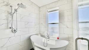 Full bath featuring a freestanding bath and tiled shower