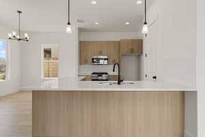 Kitchen with tasteful backsplash, hanging light fixtures, light stone countertops, recessed lighting, and appliances with stainless steel finishes