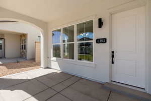 View of exterior entry with a patio and stucco siding