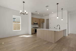 Kitchen with a peninsula, backsplash, recessed lighting, appliances with stainless steel finishes, and pendant lighting