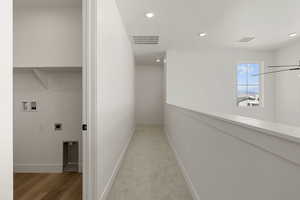 Hallway with recessed lighting and light colored carpet