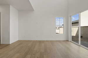 Unfurnished room with light wood-style floors and a high ceiling