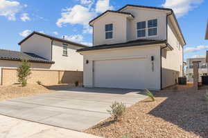 View of front of home with driveway, stucco siding, a garage, and a tile roof