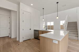 Kitchen with a peninsula, pendant lighting, light wood finished floors, dishwasher, and recessed lighting