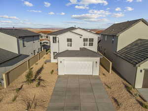 Traditional home featuring stucco siding, concrete driveway, and a residential view