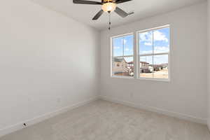 Empty room featuring carpet flooring, a residential view, and ceiling fan