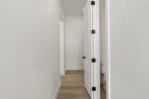 Hall with baseboards and light wood-type flooring