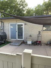 Property entrance featuring brick siding and a patio