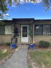 Doorway to property featuring brick siding