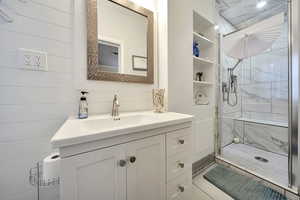 Full bath with a marble finish shower and vanity