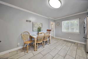 Dining room featuring ornamental molding and baseboards