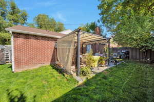 Rear view of property with brick siding, a chimney, and roof with shingles