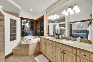 Ensuite bathroom with lofted ceiling, double vanity, a bath, recessed lighting, and a stall shower