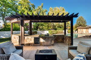 View of patio / terrace with a pergola, beverage cooler, and an outdoor living space with a fire pit