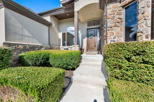 Entrance to property featuring stone siding and stucco siding