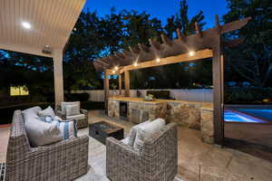 Patio at twilight featuring a pergola, a patio, a fenced backyard, an outdoor living space with a fire pit, and a pool with connected hot tub