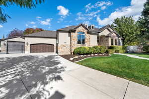 French provincial home featuring stone siding, driveway, and an attached garage