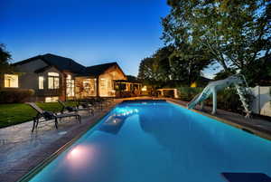 Outdoor pool with a water slide and a patio