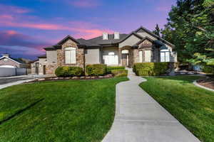 French country style house with stone siding, stucco siding, a gate, and driveway