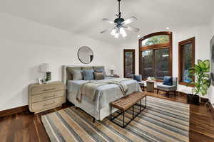 Bedroom with walnut hardwood flooring, vaulted ceiling, and ceiling fan