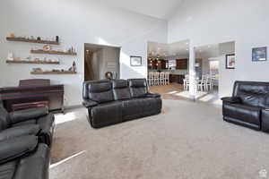 Living room featuring light colored carpet, high vaulted ceiling, and recessed lighting