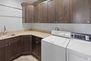 Washroom featuring cabinet space and washer and clothes dryer