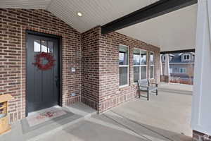 Property entrance with brick siding and covered porch