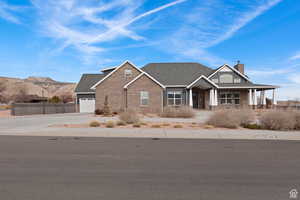 Craftsman-style house with concrete driveway, a chimney, brick siding, a garage, and a shingled roof