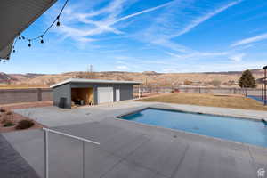 View of pool featuring a mountain view, an outbuilding, and a patio area