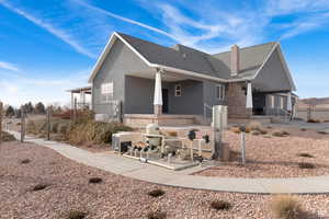 View of front of home featuring roof with shingles, a chimney, stucco siding, and a patio