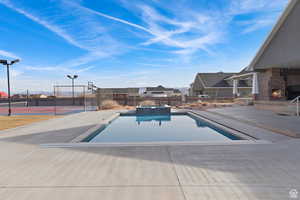 View of pool featuring a patio, a pool with connected hot tub, and a residential view