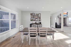 Dining area with recessed lighting, light wood finished floors, and a fireplace