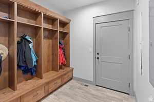 Mudroom featuring light wood finished floors and baseboards