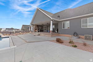Rear view of house featuring a patio area, roof with shingles, stucco siding, and ceiling fan