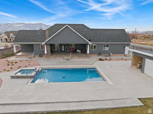 View of swimming pool with a patio, a pool with connected hot tub, and a mountain view