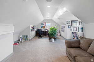 Office area with a textured ceiling, light colored carpet, and vaulted ceiling